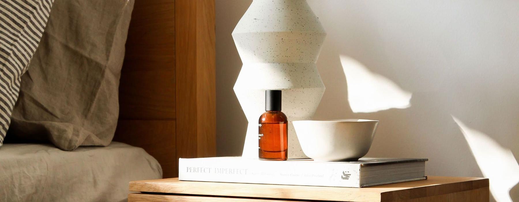 a vase with cotton stems on a bedside table