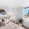 a bedroom with a bed and a window with a painting on the wall