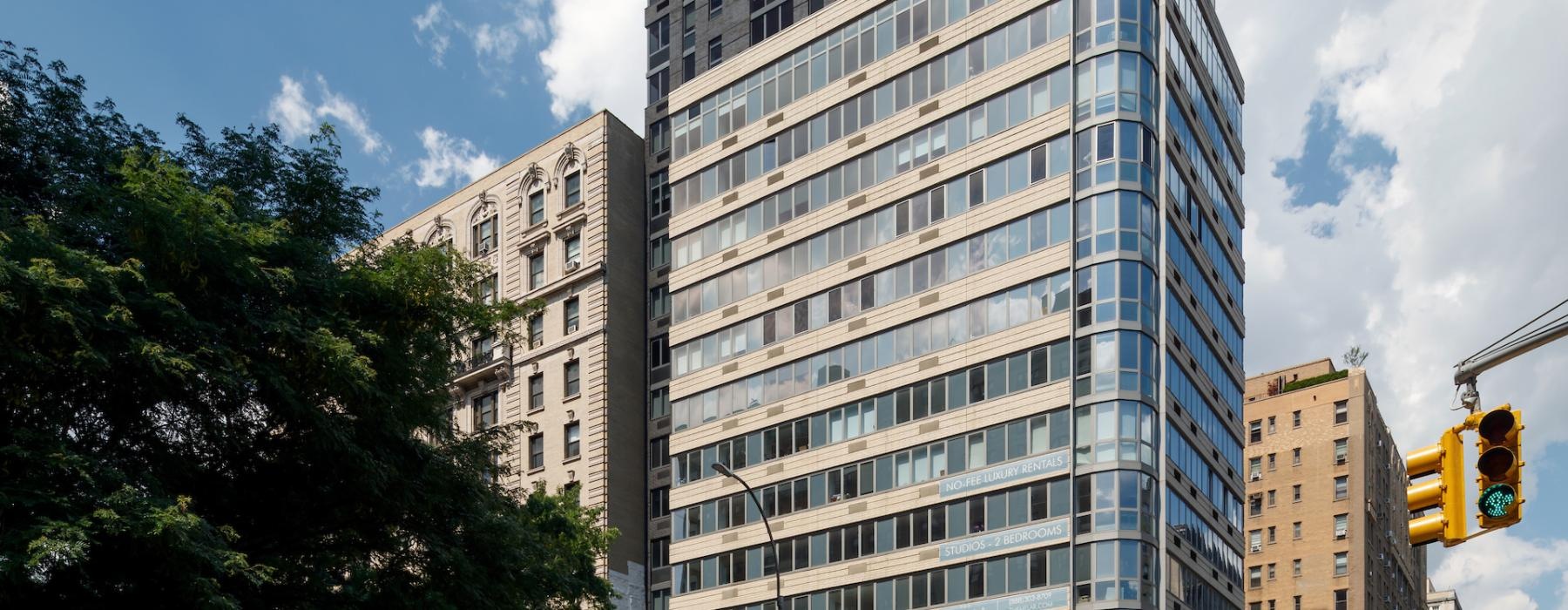 a tall building with a street and cars in front of it